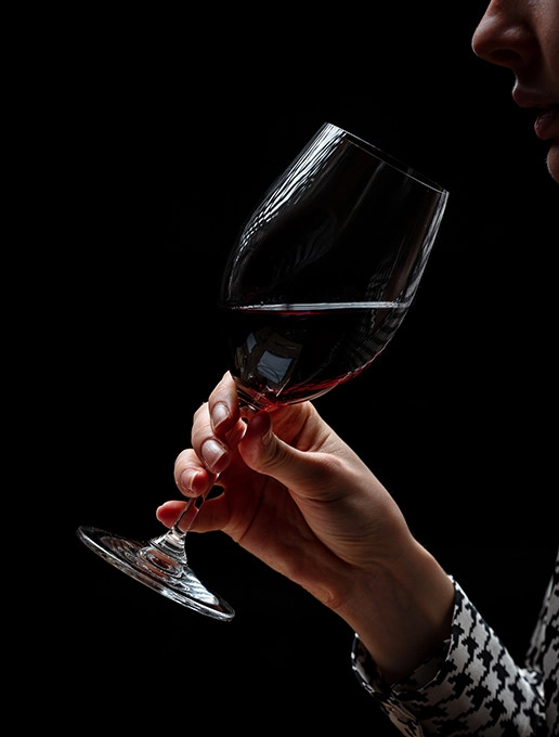 A young woman savouring a glass of wine in a cozy atmosphere to celebrate Christmas at the Dans le Noir ? restaurant