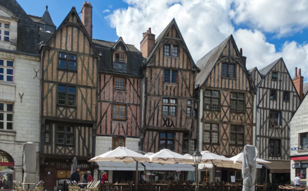 Maisons à colombages sur la place Plumereau dans le centre historique de Tours, avec terrasses de cafés et architecture emblématique du Vieux-Tours.