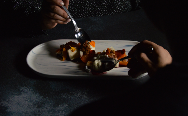 Convives dégustant un plat dans une ambiance sombre chez Dans le Noir ? Tours, pour une expérience sensorielle immersive.