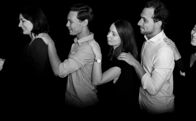 Groupe de collaborateurs en file indienne dans l’obscurité, illustrant une expérience sensorielle de cohésion lors d’un dîner d’entreprise insolite.